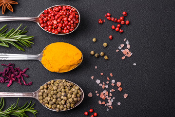 Variation of spices in metal spoons paprika, turmeric, cardamom, a mixture of allspice, thyme and rosemary