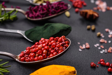 Variation of spices in metal spoons paprika, turmeric, cardamom, a mixture of allspice, thyme and rosemary