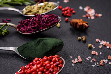 Variation of spices in metal spoons paprika, turmeric, cardamom, a mixture of allspice, thyme and rosemary