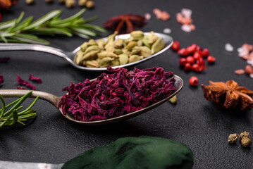 Variation of spices in metal spoons paprika, turmeric, cardamom, a mixture of allspice, thyme and rosemary