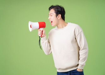 Image of young Asian man holding speaker on background