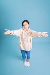 Photo of young Asian girl posing on blue background