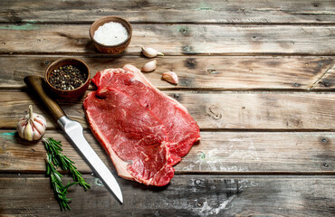Raw marbled beef steak with spices.