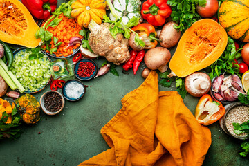 Food background. Vegetables, mushrooms, roots, spices - ingredients for vegan, cooking. Orange...