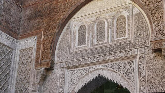 Beautiful carvings on the ancient walls of the medina in Fes Morocco with perfect proportions. The architectural masterpiece is decorated with Arabic script and picturesque floral ornaments.