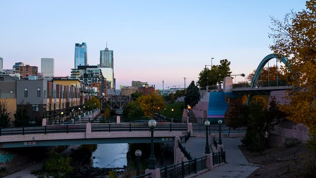 Day to night time lapse of blurred people walking along the Cherry Creek trail in Denver, Colorado.