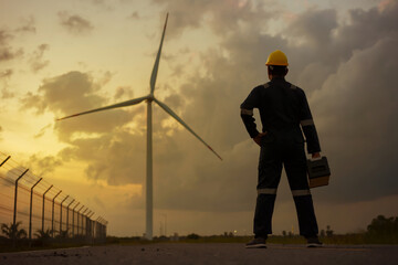 Asian man engineer preparing and checking of a wind turbine with safety in wind farm.