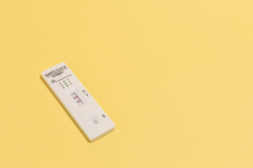 Close up image of Rapid test kit device for Covid-19 on yellow surface