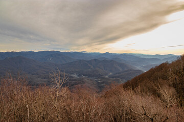 Mountain peaks of the Caucasus on a sunny day. Stunning view of the mountain landscape from a height. A magnificent mountain range with high rocky peaks. View from a height of 1000 m.