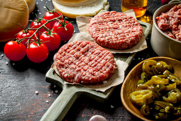 Raw burgers with jalapeno chillies, tomatoes and scones.