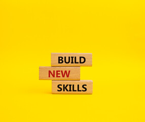 Build New skills symbol. Concept word Build New skills on wooden blocks. Beautiful yellow background. Business and Build New skills concept. Copy space