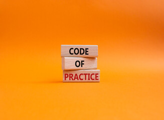 Code of Practice symbol. Concept word Code of Practice on wooden blocks. Beautiful orange background. Business and Code of Practice concept. Copy space