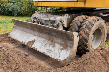 Excavator or bulldozer bucket flattens the ground or road in the industrial zone or construction site © Andrey