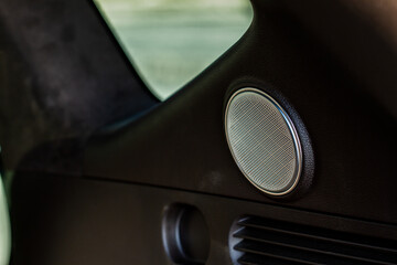 Sound speaker in a modern car trunk. Close up car speaker inside car door.