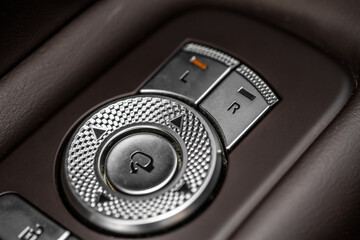 Side mirrors control panel on side door. Car driver adjust side mirror controller. Side mirror control button for adjusting the mirrors.