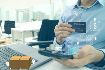 Businessman holding smartphone for shopping online, use credit card for payment. A parcel box is placed on a laptop computer. cart, basket, dollar icon on screen. Payment online concept.