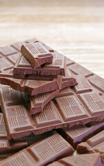 Closeup pile of delectable chocolate chunks on wooden background