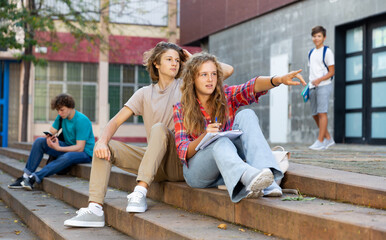 Girl points her finger to guy on the street during a break in college