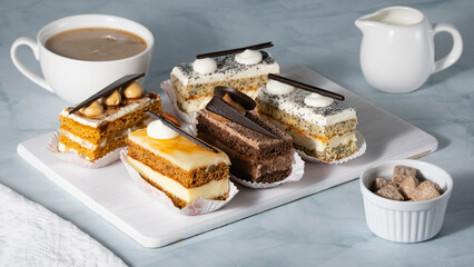 A set of delicious cakes and coffee on a light table