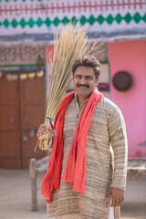 Indian man cleaning house with broom