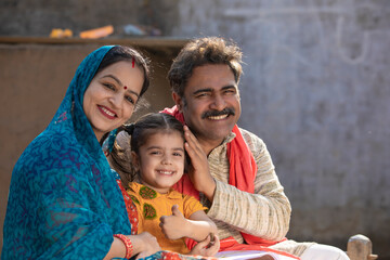 Obraz premium Happy indian farmer couple with little daughter at home.