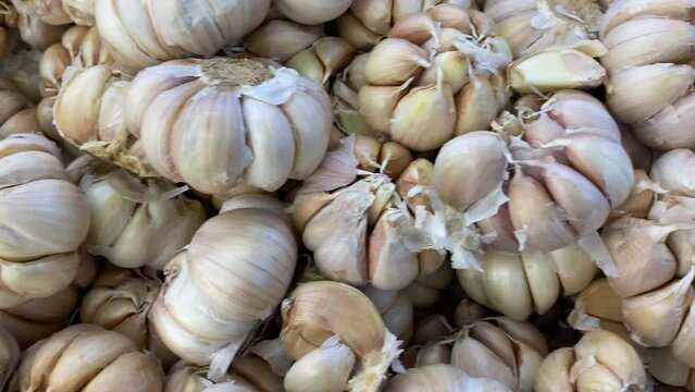 Pan right top view of pile of fresh asian garlic in traditional market.
