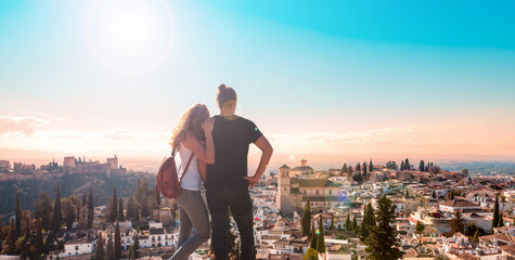 Couple tourist looking at Ancient arabic fortress Alhambra- Granada in Spain - obrazy, fototapety, plakaty