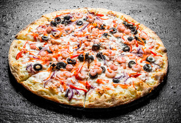 Pizza with shrimp, olives and red onions.