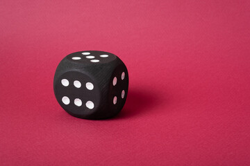 Large playing black cube on a magenta background with room for design