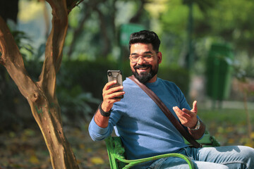 Indian man using smartphone at park
