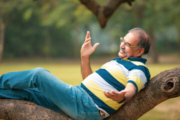 Fototapeta premium Happy senior man relaxing and enjoying retirement life at park.