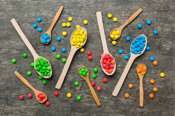delicious colorful sweet candies on spoon on colored background . Confectionery decor top view with copy space