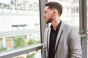 Fototapeta premium Start-Up Gründer blickt nachdenklich aus dem Fenster