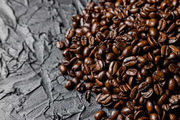 Roasted coffee beans on black design board.