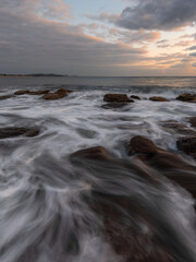 Water flowing between rocks on the coastline.