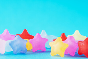 Background of multicolored stars on blue background. Greeting card for the holiday and a place for the text.