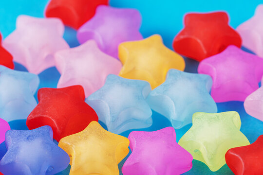 Background of multicolored stars on blue background. - Powered by Adobe