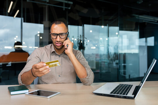 Dissatisfied Businessman In The Office With A Bank Credit Card Calls Customer Support, Blocked Card Man Can't Make A Purchase In An Online Store.