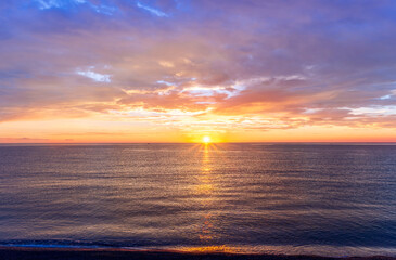 view at sunrise or sunset in sea with nice beach , surf , calm water and beautiful clouds on a background of a sea landscape