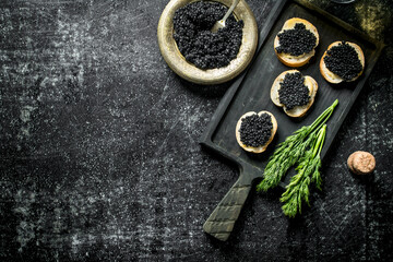 Black caviar on bread slices with dill.