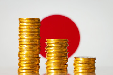 Crisis in Japan concept. Golden coins forming negative chart in front of flag of Japan