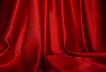 Bright red curtains are beautifully wavy, close-up.