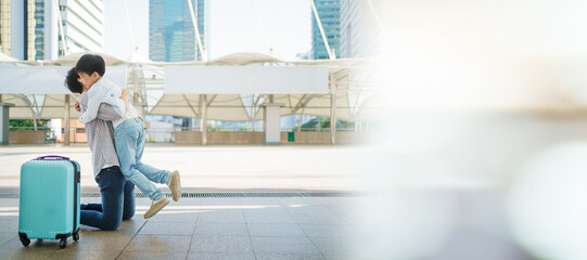 Happy cheerful Asian little boy running to his father at the railway or sky train station after his...