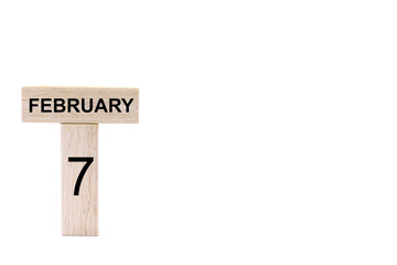 February 7 displayed wooden letter blocks on white background with space for print. Concept for calendar, reminder, date. 