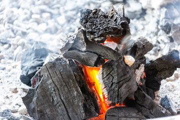 Close-up of burning coal in the fireplace. Burned charcoal in the grill.