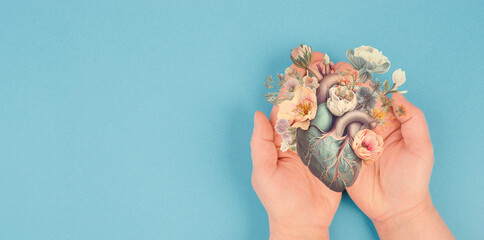 Hands holding human heart with flowers, love and emotion concept,  good hearted person, help and...