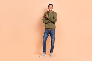 Fototapeta premium Full length photo of attractive joyful man wear khaki clothes arm direct empty space positive feedback isolated on beige color background