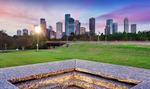 Downtown Houston from Police Memorial park at dramatic sunset. Green park lawn and modern skylines. The most populous city in Texas, and fourth-most in United States.