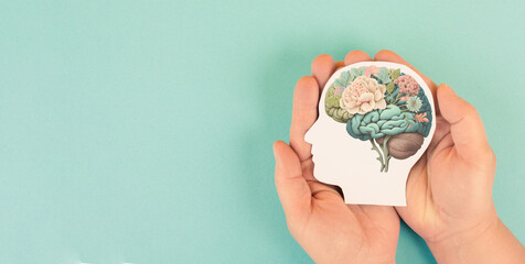 Hands holding paper head, human brain with flowers, self care and mental health concept, positive thinking, creative mind, generative AI used for brain