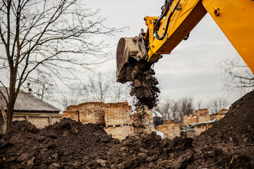 The earthmover is removing soil on construction site.